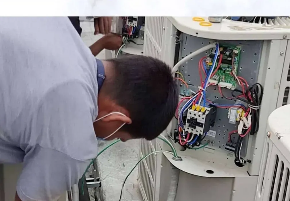 Técnico de Fondach revisando la conexión eléctrica de una unidad condensadora