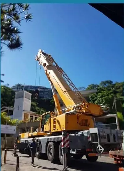Grúa telescópica posicionando un chiller en la azotea de un edificio