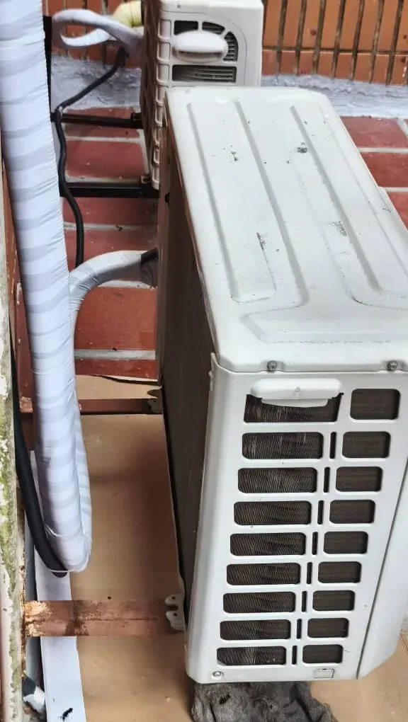 Unidad condensadora instalada en una terraza con tuberías aisladas