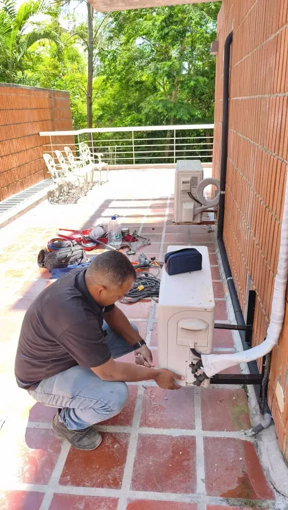 Técnico de Fondach instalando una unidad condensadora en una terraza