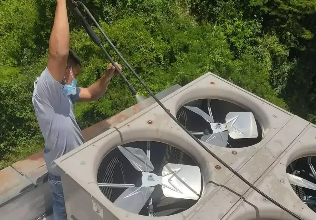 Técnico de Fondach lavando una condensadora industrial en una azotea
