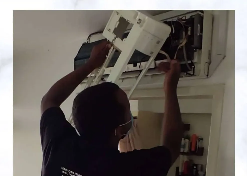 Técnico haciendo mantenimiento a un split interior